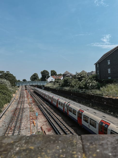 Interior view of Finsbury Park London Underground station showing a platform with a moving train on the right side, with visible roundel symbols on the train indicating the London Underground service.